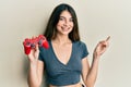 Young caucasian woman playing video game holding controller smiling happy pointing with hand and finger to the side Royalty Free Stock Photo