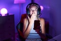 Young caucasian woman playing video games with smartphone covering mouth with hand, shocked and afraid for mistake Royalty Free Stock Photo