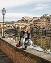 Young caucasian woman posing in front of amazing bridge Ponte Vecchio, Florence, Italy Royalty Free Stock Photo