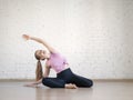 Young caucasian woman practise pilates in fitness studio, mermaid pose, selective focus.