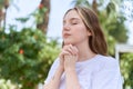 Young caucasian woman praying with closed eyes at park Royalty Free Stock Photo