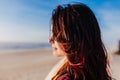 Young caucasian woman relaxing at the beach at sunset. Selective focus on hair flying on a windy day. Holidays and relaxation Royalty Free Stock Photo