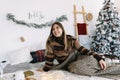 Young caucasian woman relaxing on a bed at home in Christmas holidays Royalty Free Stock Photo