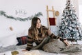 Young caucasian woman relaxing on a bed at home in Christmas holidays Royalty Free Stock Photo