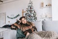 Young caucasian woman relaxing on a sofa at home in christmas holidays Royalty Free Stock Photo