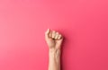 Young caucasian woman`s hand with clenched fist on fuchsia pink background. Women power independence freedom equality Royalty Free Stock Photo