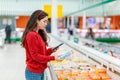 A young Caucasian woman scans the qr code on the package with a semi-finished product. Concept of modern technologies and shopping Royalty Free Stock Photo