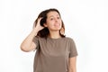 A young Caucasian woman is scratching her hair from dandruff and irritation. White background. The concept of hair care Royalty Free Stock Photo