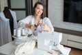 Young caucasian woman sews at home