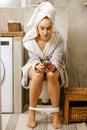 Beautiful woman sit in toilet with mobile phone Royalty Free Stock Photo