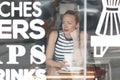 Young caucasian woman sitting alone in coffee shop thoughtfully leaning on her hand, looking trough the window Royalty Free Stock Photo