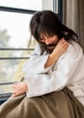 Young caucasian woman sitting comfortably on the window ledge after a bath