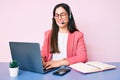 Young caucasian woman sitting at the desk wearing call center agent headset working using laptop looking positive and happy Royalty Free Stock Photo