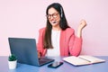 Young caucasian woman sitting at the desk wearing call center agent headset working using laptop screaming proud, celebrating Royalty Free Stock Photo