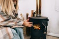 Young caucasian woman sitting in living room near fireplace in country house and warms his hands Royalty Free Stock Photo