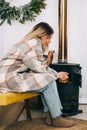 Young caucasian woman sitting in living room near fireplace in country house and warms his hands Royalty Free Stock Photo