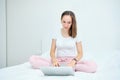 Young caucasian woman sitting on sofa and using laptop at home Royalty Free Stock Photo