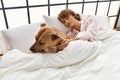 Young caucasian woman sleeping lying on bed with dog at bedroom Royalty Free Stock Photo