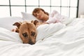 Young caucasian woman sleeping lying on bed with dog at bedroom Royalty Free Stock Photo