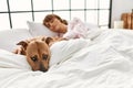 Young caucasian woman sleeping lying on bed with dog at bedroom Royalty Free Stock Photo