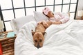 Young caucasian woman sleeping lying on bed with dog at bedroom Royalty Free Stock Photo
