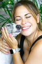 Young Caucasian woman smiles tenderly while hugging her greyhound dog. Animal love concept