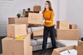 Young caucasian woman smiling confident holding fragile package at new home