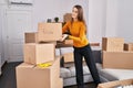 Young caucasian woman smiling confident holding fragile package at new home