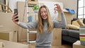 Young caucasian woman smiling holding new house keys taking selfie at new home Royalty Free Stock Photo