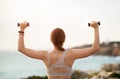 Young caucasian woman in sportswear doing arm exercise with dumbbells, back, enjoy training Royalty Free Stock Photo