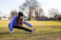 A young Caucasian woman in sportswear is engaged in warm-up and fitness in the Park. Stretching legs. Concept of sport Royalty Free Stock Photo