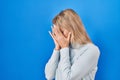 Young caucasian woman standing over blue background with sad expression covering face with hands while crying Royalty Free Stock Photo
