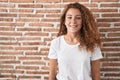 Young caucasian woman standing over bricks wall background with a happy and cool smile on face Royalty Free Stock Photo
