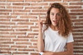 Young caucasian woman standing over bricks wall background pointing finger up with successful idea Royalty Free Stock Photo