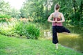 Young blond woman standing in yoga pose on one leg with hands as in prayer Royalty Free Stock Photo