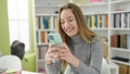 Young caucasian woman student using smartphone at library university Royalty Free Stock Photo