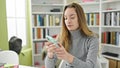 Young caucasian woman student using smartphone at library university Royalty Free Stock Photo