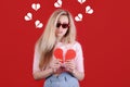 Young caucasian woman in sunglasses with broken red heart in hands. Royalty Free Stock Photo