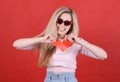 Young caucasian woman in sunglasses with broken red heart in hands. Royalty Free Stock Photo