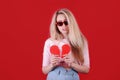 Young caucasian woman in sunglasses with broken red heart in hands. Royalty Free Stock Photo