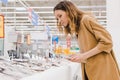 Young caucasian woman with a tablet picks fish in a supermarket