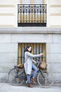 Young Caucasian woman taking a photo with mobile phone next to a classic touring bike Royalty Free Stock Photo