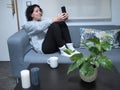 Young caucasian woman taking a selfie in pajamas, sitting on the sofa with a cup of coffee Royalty Free Stock Photo