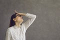 Young caucasian woman touching forehead regrets wrong doing studio shot