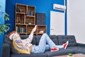 Young caucasian woman using air condition machine lying on sofa at home Royalty Free Stock Photo