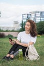 Young caucasian woman using her smartphone for internet surfing lying on a green grass Royalty Free Stock Photo