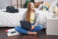 Young caucasian woman using laptop sitting on floor at bedroom Royalty Free Stock Photo