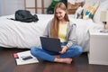 Young caucasian woman using laptop sitting on floor at bedroom Royalty Free Stock Photo