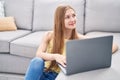 Young caucasian woman using laptop sitting on floor at home Royalty Free Stock Photo