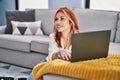Young caucasian woman using laptop sitting on floor at home Royalty Free Stock Photo